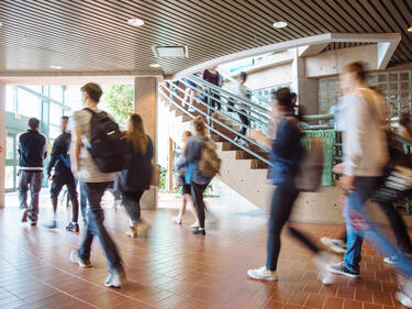 Blurred students walking to class through front foyer of school