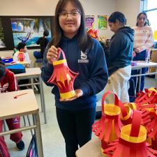 Middle school student showing their handmade paper lantern.