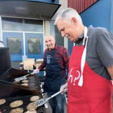 Trustee Petersen and fellow friend BBQing burgers in front of Yale Secondary.